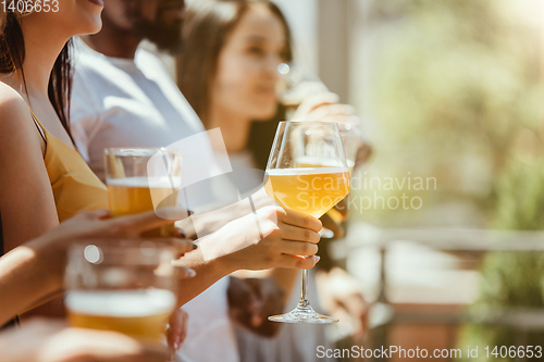 Image of Young group of friends drinking beer and celebrating together