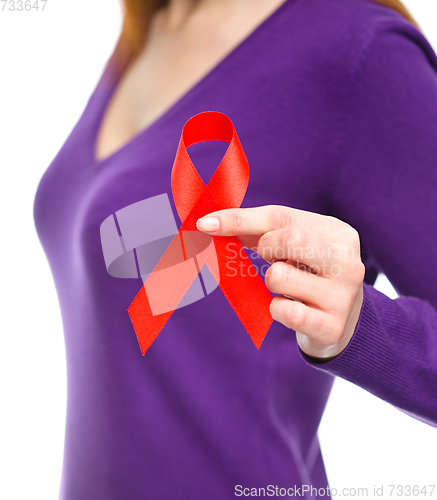 Image of Woman is holding the red awareness ribbon