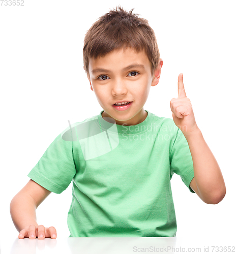 Image of Little boy is pointing up using his index finger