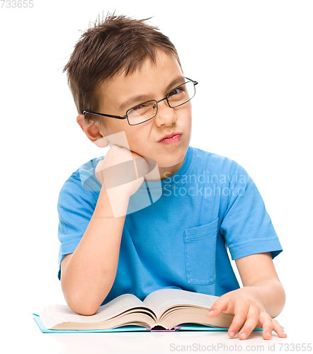 Image of Little boy is tired to read his book