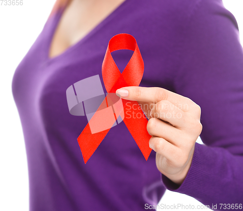 Image of Woman is holding the red awareness ribbon