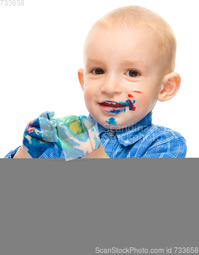 Image of Little boy is playing with paints