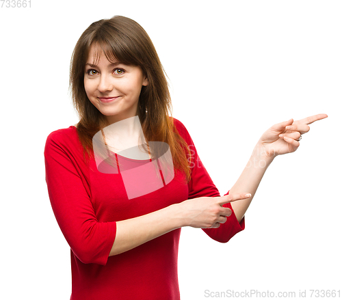 Image of Portrait of a young woman pointing to the right