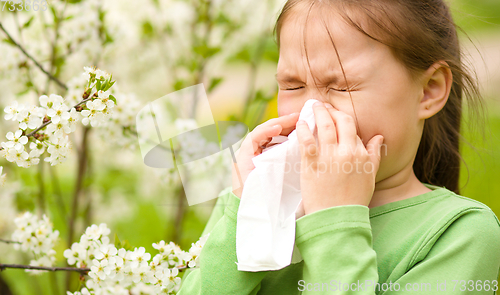 Image of Little girl is blowing her nose