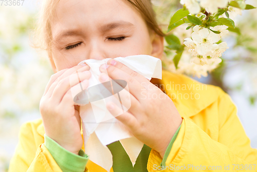 Image of Little girl is blowing her nose