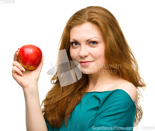 Image of Young happy girl with apple