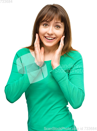 Image of Woman is holding her face in astonishment