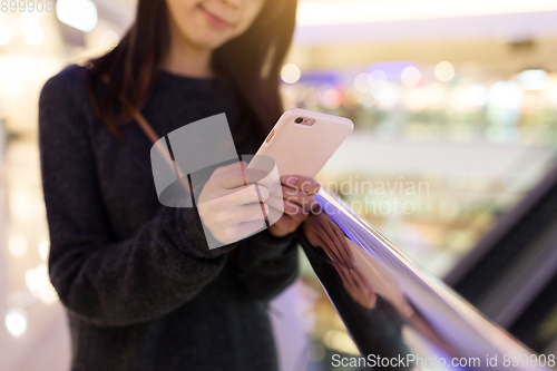 Image of Young Woman sending text message in mobile phone
