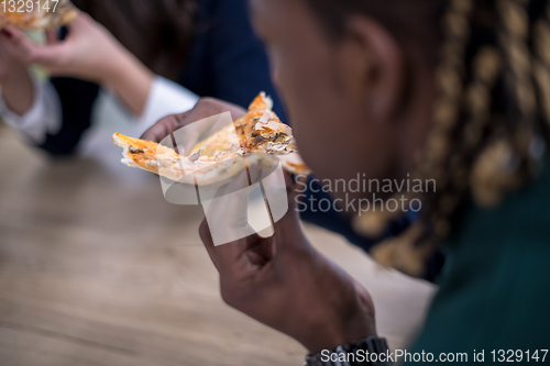 Image of multiethnic business team eating pizza