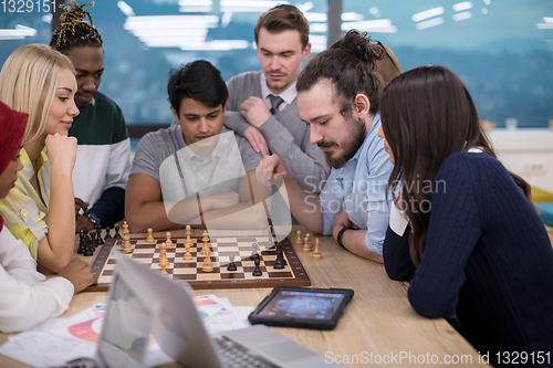 Image of multiethnic group of business people playing chess