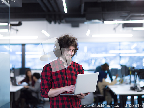 Image of smiling male software developer using laptop