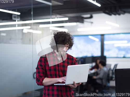 Image of smiling male software developer using laptop