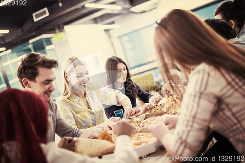 Image of multiethnic business team eating pizza