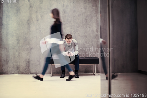 Image of businessman using mobile phone while sitting on the bench