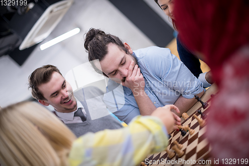 Image of multiethnic group of business people playing chess