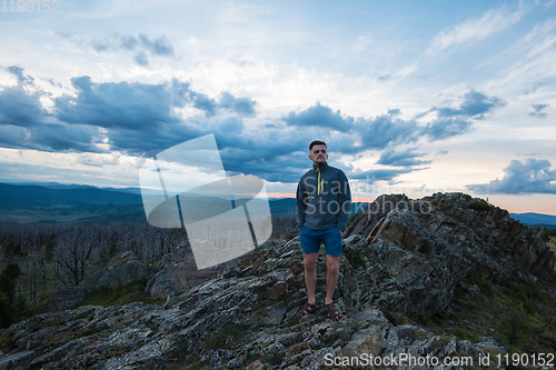 Image of Man standing on top of cliff