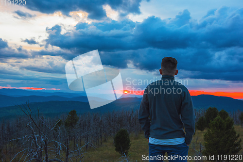 Image of Man standing on top of cliff