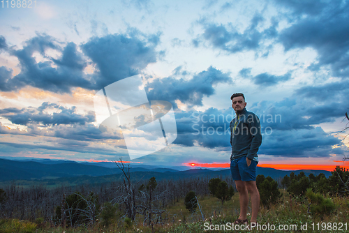 Image of Man standing on top of cliff