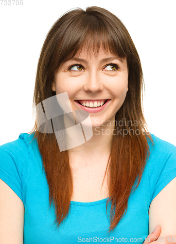 Image of Young happy woman is looking up and smile