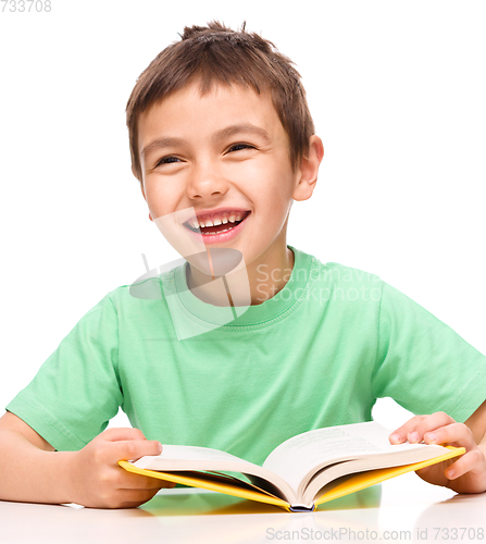 Image of Little boy plays with book