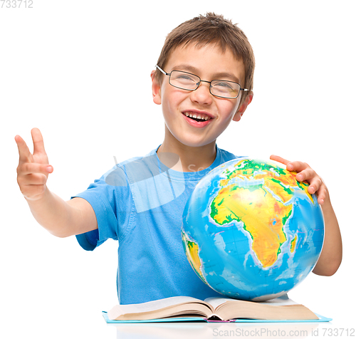 Image of Little boy is holding globe