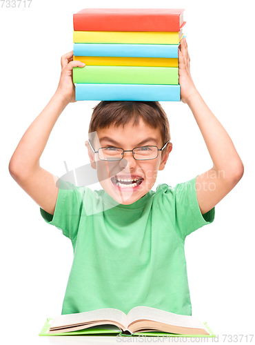 Image of Little boy is holding a pile of books