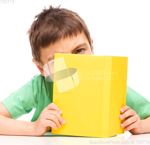Image of Little boy plays with book