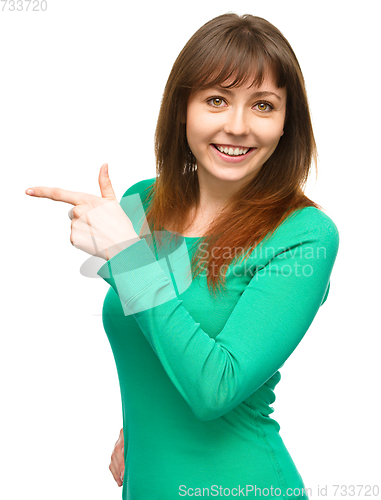 Image of Portrait of a young woman pointing to the left