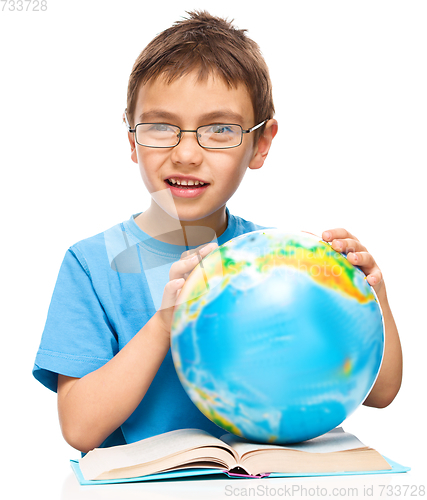 Image of Little boy is holding globe