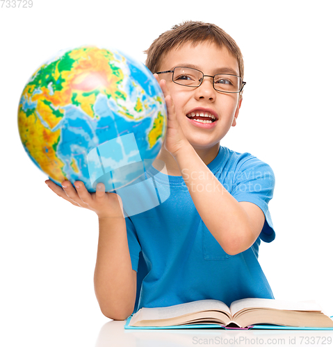 Image of Little boy is holding globe
