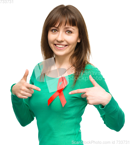 Image of Woman is pointing to the red awareness ribbon