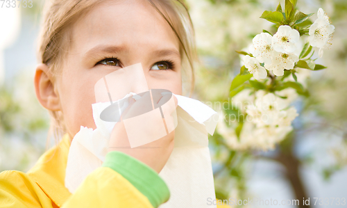 Image of Little girl is blowing her nose