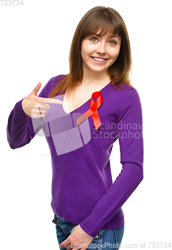 Image of Woman is pointing to the red awareness ribbon