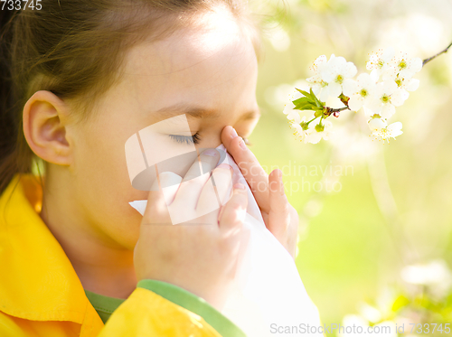 Image of Little girl is blowing her nose