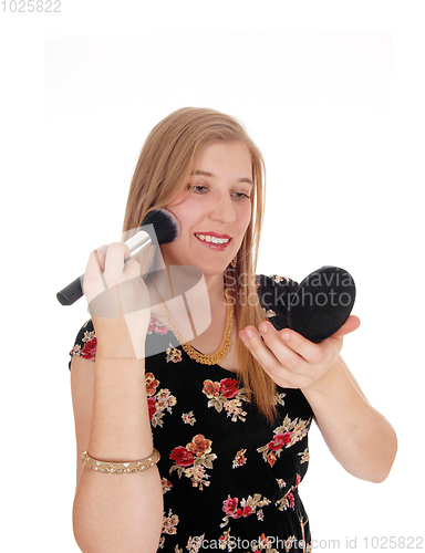 Image of Beautiful woman putting on makeup