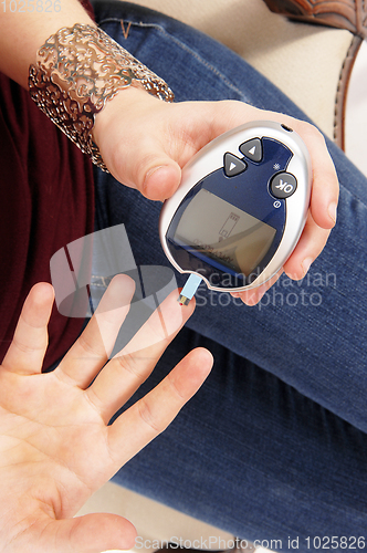 Image of Woman testing her blood sugar