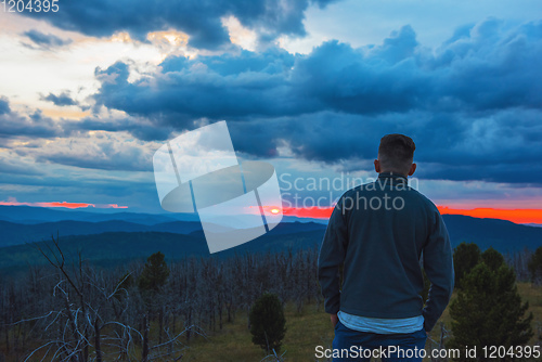 Image of Man standing on top of cliff