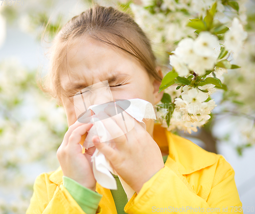 Image of Little girl is blowing her nose