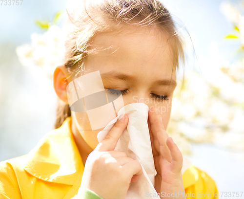 Image of Little girl is blowing her nose