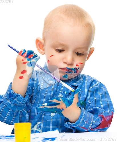 Image of Little boy is playing with paints