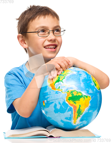 Image of Little boy is holding globe