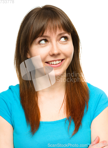Image of Young happy woman is looking up and smile