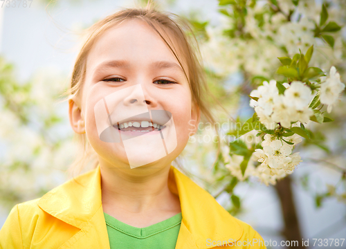 Image of Portrait of a little girl near tree in bloom