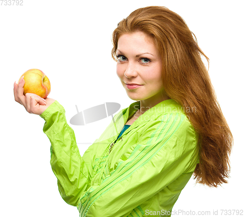 Image of Young happy girl with apple