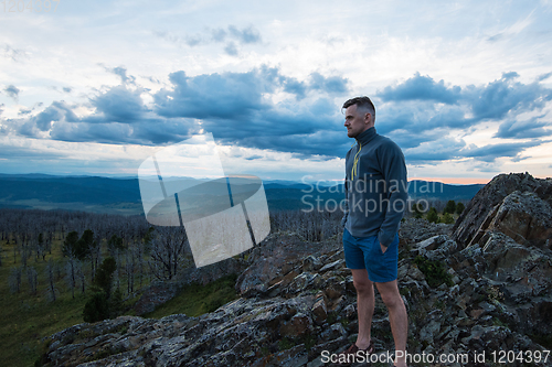 Image of Man standing on top of cliff