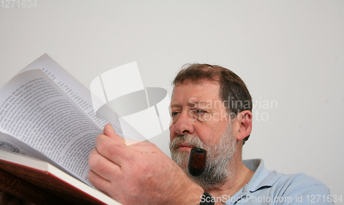 Image of Mature scandinavian man reading a book 