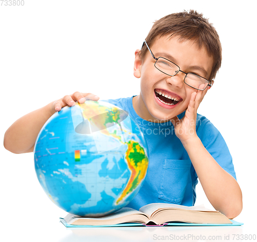 Image of Little boy is holding globe