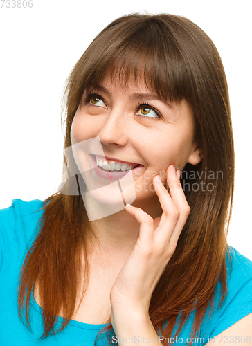 Image of Young woman is touching her cheek with hand