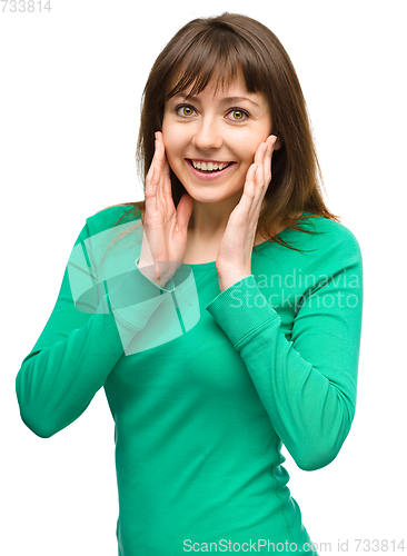 Image of Woman is holding her face in astonishment