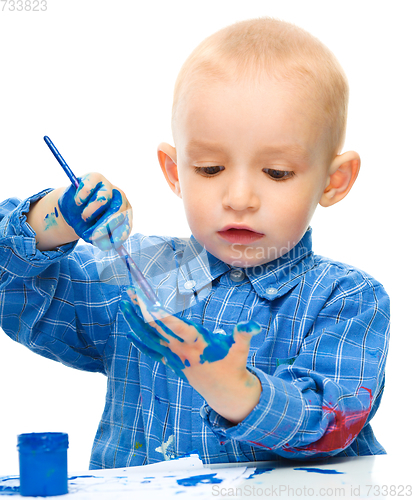 Image of Little boy is playing with paints